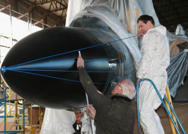 Hangar boss Ray Burrows (left) and painter Ian Hendry do some precise measuring during the final stages of restoration on the Society's Phantom.