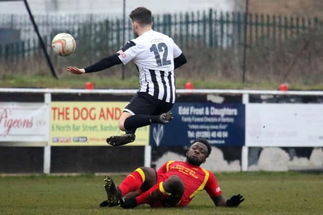 Banbury United's Jordy Ngarthe fails to stop  St Ives Town's Eugene Libertucci