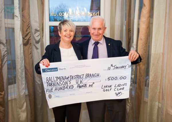 Barbara Wilson Lady Captain Larne Ladies Golf Club presents a cheque to Maurice Adams of Ballymena and District Branch Parkinsons UK.