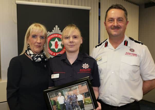 Trainee Firefighter Control Operator from Larne, Emma Burns, celebrates her graduation with Carmel McKinney, OBE, NIFRS Chairperson and Gary Thompson, Chief Fire & Rescue Officer