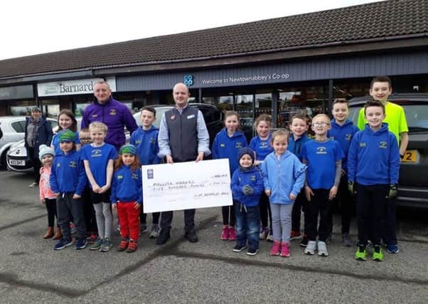 Staff from Co-Op Newtownabbey present a donation to Mallusk Harriers for junior development programme