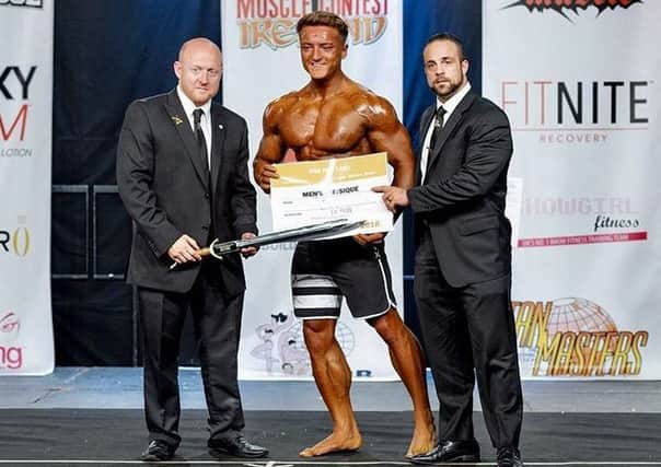 Josh Coyle receives his prize for winning the Men's Physique class at the IFBB  Muscle Contest Ireland event in Limerick.