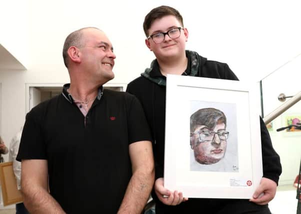 Justin Cole (15), from Dunclug College, Ballymena, is a winner in this year's 64th Texaco Children's Art Competition. He is pictured with his prize-winning self-portrait work alongside his father Eric. (submitted image).