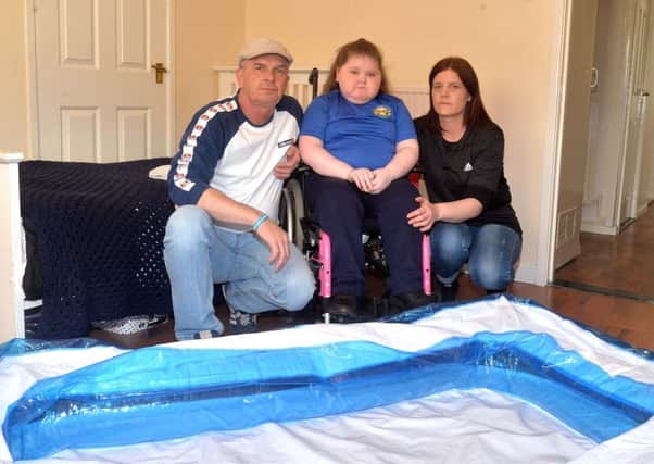 Hannah Shortall with her parents, Brendan and Kelly pictured with the paddling pool she is forced to use as a bath. INLM17-201.
