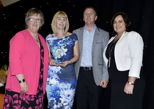 Dromore couple Julie and Evan Jones receive their award from Una Carragher (left), manager of the Regional Adoption and Fostering Service, and Kathleen Toner (right), director of The Fostering Network in Northern Ireland.