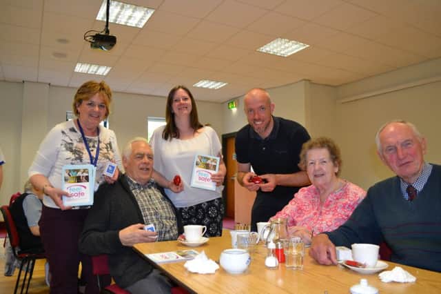 L-R: Nuala McGoldrick, patch manager with the Housing Executive with Jenni Archer, Neighbourhood Renewal officer from Causeway Coast and Glens Council and Steve McCrudden from Age Concern Causeway distribute personal alarms and information leaflets to members of the lunch club in the West Bann Development Centre.