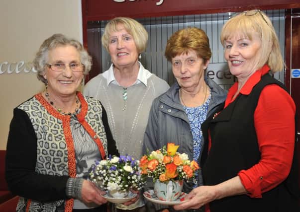 Agnes Wharry, Gladys Smyth, Moira McAllister and Margaret McMullan take a keen interest in some of the flower arrangements on display at the Slemish Area WI AGM.