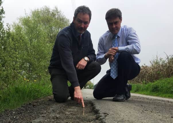 Councillor William McCaughey and Paul Frew MLA highlight concerns over the condition of the Tullynamullan Road.