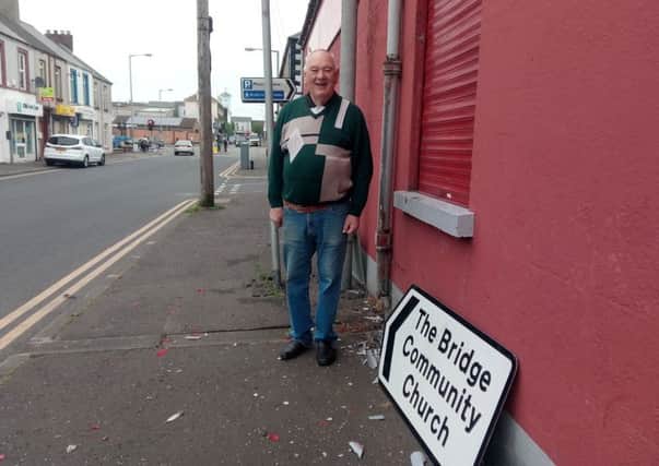 Mr Dermond Maxwell outside his clothing store in Union Street where a car crashed into his wall and a pole