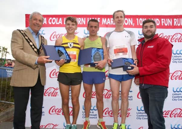 Councillor Uel Mackin and Public Affairs and Communications Co-ordinator of Coca-Cola HBC Northern Ireland, Stuart McCrum present Keith Shields, Conal McCambridge and Daniel Stauber with first, second and third place in the Mens Half Marathon race.