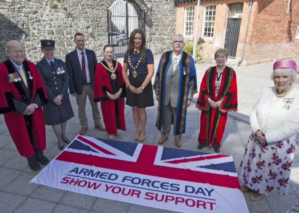 Mrs Joan Christie CVO, OBE, Her Majestys Lord-Lieutenant for the County of Antrim, preparing to raise the flag at Carrick Town Hall.