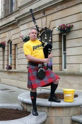 Ulster Bank Coleraine branch manager William Black pictured busking outside the branch to help raise funds for depression charity AWARE.