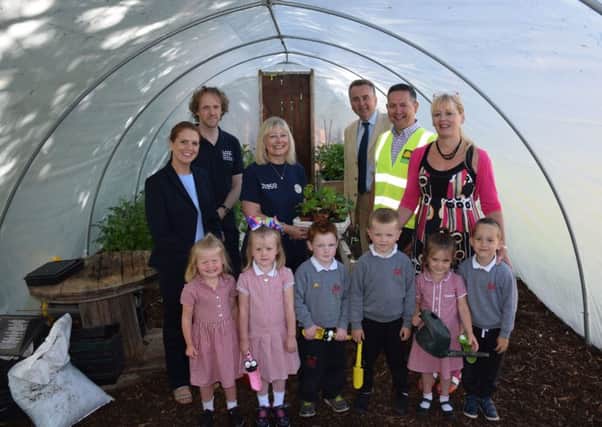 Pictured in the new polytunnel at Fort Hill Integrated Primary School are school pupils and the School Principal along with representatives from Tesco Lisburn, Lisburn & Castlereagh City Council and J P Corry who helped the school with this green project.