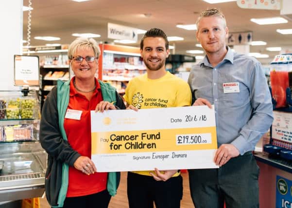 Eurospar Customer Advisor, Irene Hunter presents Andy Boal, Community Fundraiser at Cancer Fund for Children with a cheque for almost Â£20,000. Also pictured is store manager, Daniel.