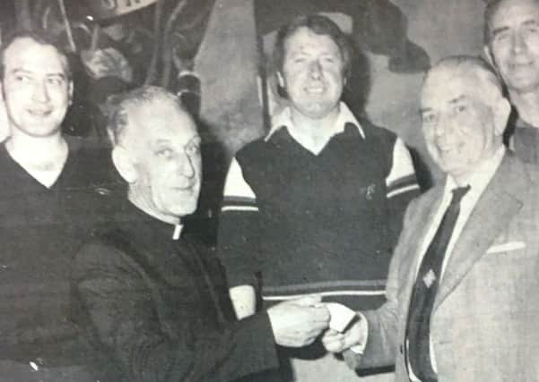 Father O'Connell received a cheque from Mr Jim Brady, Chairman of the INF Club in 1981 after they raised Â£150 at a charity dance Also pictured are Gerald Tow, Gerald Eagers, and Michael Fitzdsimmons.