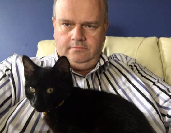 Photographer Kevin  McAuley with his cat O'Malley which was poisoned.