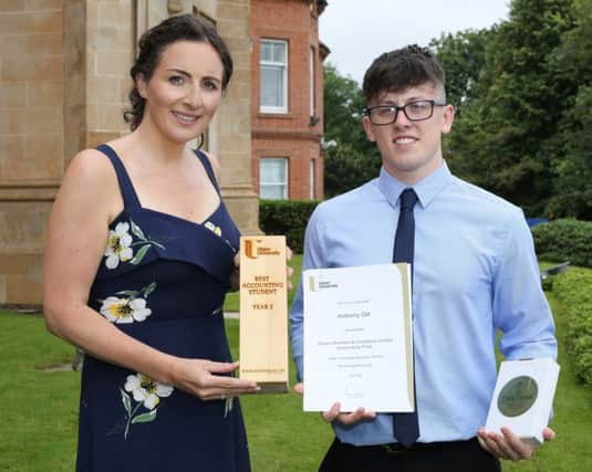 Anthony Gill is pictured receiving his award from Claire Scott McAteer, Ulster University Business School.