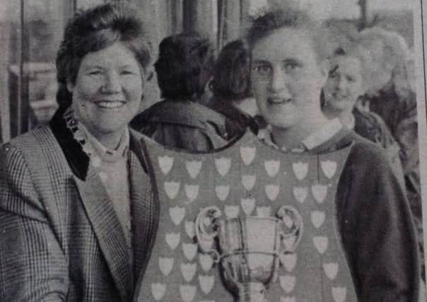 Oona Boyce, captain of the Ballymena Academy team which defeated Strathearn in the Ulster Schoolgirls' Hockey Final, receives the cup from Mrs Joan McCloy, president of the Ulster Women's Hockey Association. 1989.
