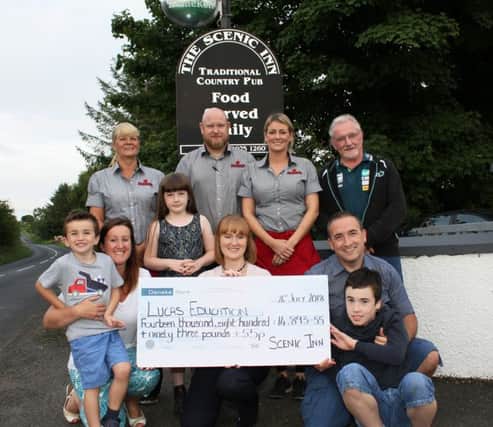 Barbara McMullan (front centre) along with her daughter, Lily, presents a cheque for Â£14,893.55p. to Nigel and Rosie Bovaird for the couple's LUCAS Education appeal fund. The money was raised by David and Barbara McMullan over a four month period as a result of a number of initiatives held at The Scenic Inn, Armoy, whose management assisted greatly in the overall contribution. Included are Lucas Bovaird (right front)  who has a rare condition called Phelan McDermid syndrome and who is also severely autistic. Also pictured are Scenic Inn management, Shirley McKinley and Steven and Pamela McFetridge and Tom Christie who assisted in the fund-raising programme.