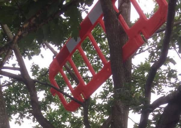 A barrier and shopping trolley were thrown into a tree.
