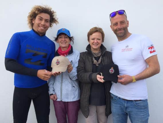 Anne McIntyre and Sybil Langford Donaghy present Jonny Seifert (left) and Martin Kelly (right) of Portrush Surf School with the Royal Portrush GC caps.