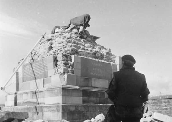 A soldier views the wreckage of the Walker monument