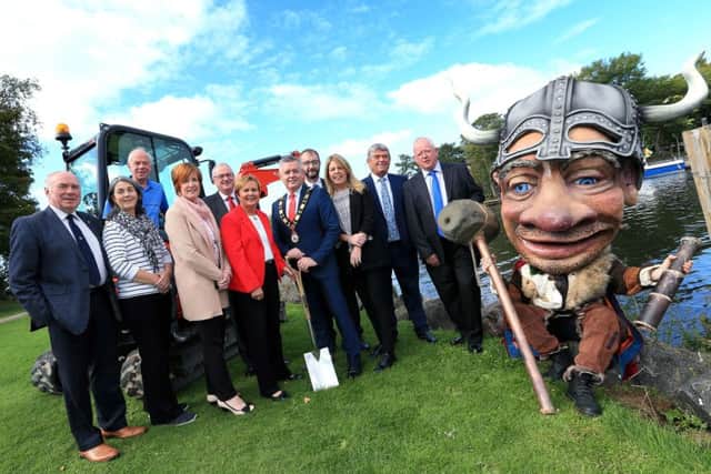 The Mayor Councillor Paul Michael officially cuts the sod of the new Lough Neagh Gateway Centre at Antrim Loughshore Park with Jacqui Dixon (Chief Executive, Antrim and Newtownabbey Borough Council), Dr William Burke (Landscape Partnership Manager), Fiona McCandless (DAERA), Elected Members and Vinnie the Viking.