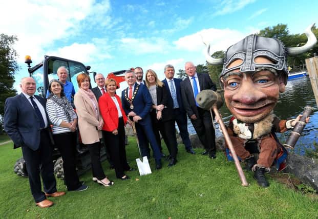 The Mayor Councillor Paul Michael officially cuts the sod of the new Lough Neagh Gateway Centre at Antrim Loughshore Park with Jacqui Dixon (Chief Executive, Antrim and Newtownabbey Borough Council), Dr William Burke (Landscape Partnership Manager), Fiona McCandless (DAERA), Elected Members and Vinnie the Viking.