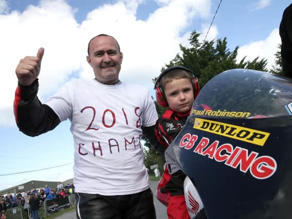Paul Robinson celebrates winning the Irish Moto3/125 Championship at Killalane on Sunday with his son Max after taking victory in his final road race. Picture: Stephen Davison.