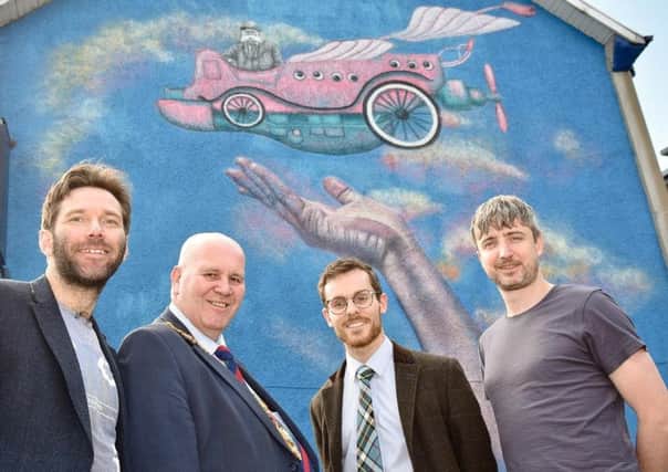 Andy King from Larne Renovation Generation, Cllr.  Paul Reid, Michael Dorman of RA Glass Opticians and artist Eoin McGinn.  The group are pictured at one of the new artworks.