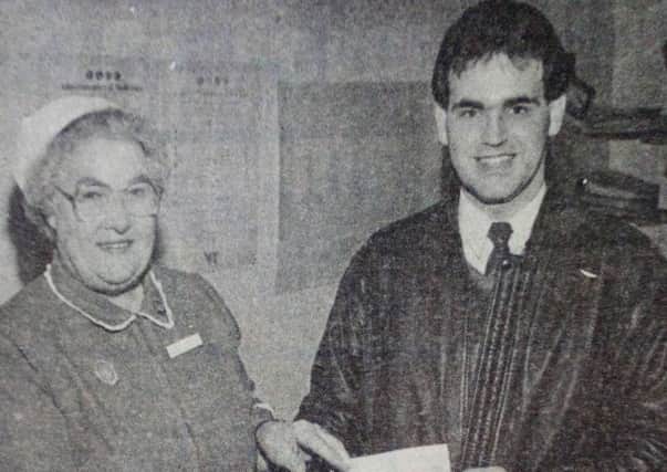 Mrs R.M. Simpson ADNS at the Braid Valley Hospital receives a cheque for Â£250 for the Braid Valley Patients' Comfort Fund from Derek Allen, chairman of the Paradise/Tower Centre Supporters' Club. The Club raised the money with a sponsored walk from Ballymena to Larne. 1989.