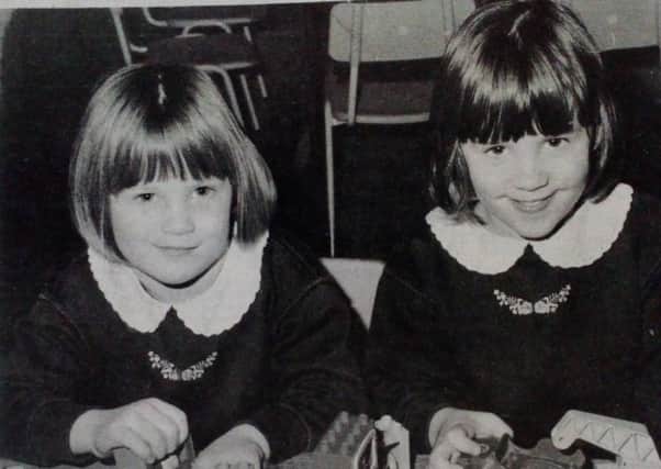 Twins Victoria and Carrie Halliday enjoy some play with building bricks and toy cars at the Greengables PlayGroup. 1991.