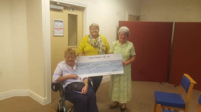 Betty Calvert and Rosemary  Dunbar presenting a cheque for Â£805 to Margaret Henry, Chairperson of Breathe Easy Causeway.