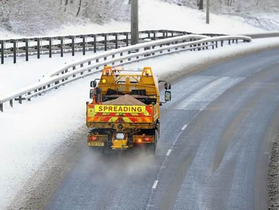 A gritter in action during snowy weather conditions.