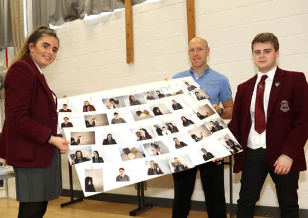 Josephine Dowell, Callum McNally and teacher Chris Donnelly from Ulidia Integrated College ready to add some of the schools winning artwork to the Carson Awards exhibition at Lagan College. Pic by Declan Roughan