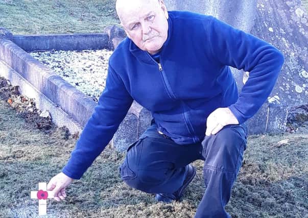 Alan Rice leaving a poppy cross on the unmarked grave.