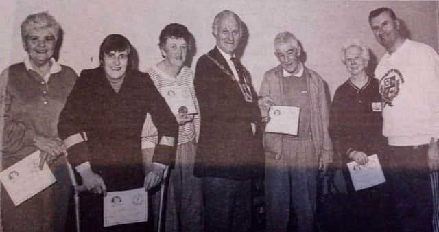 Pupils of the Ballymena Leisure Centre disabled swimming classes pictured with the Mayor, Sandy Spence, who presented them with their swimming awards at a recent ceremony in the town. Included are: Billy Morgan (coach) with Evelyn Vogan,  Elizabeth Close, Hilary McCartney, Alan Craig and Mary McAuley. 1989.