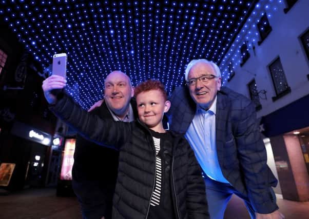 Chairman of Lisburn & Castlereagh City Council's Development Committee, Alderman William Leathem and Vice-Chairman Alderman Allan Ewart MBE getting a selfie with Taylor at the dazzling light canopy in Bow Street, as part of Lisburn Light Festival.