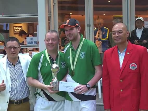 Ian McClure and Aaron Tennant receive the Hong Kong Classic Bowls Pairs trophy.