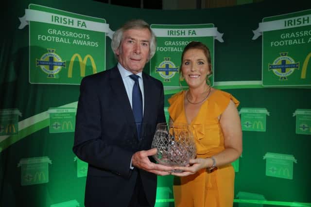 Mid-Ulster Ladies F.C. Chairperson, Elaine Junk, receives the Outstanding Contribution to Grassroots Football Award from  McDonalds Football Ambassador, Pat Jennings, at Belfast City Hall.