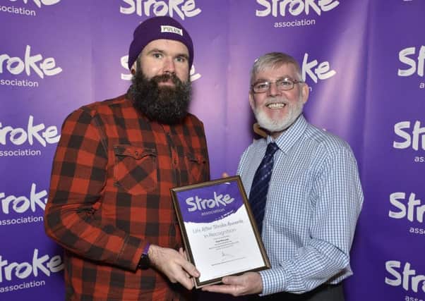 Paul McLean receiving certificate of nomination from Stroke Association committee member Peter Deazley.