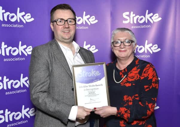Will McLean receiving certificate of nomination from Stroke Association committee Member Anne Gamble.