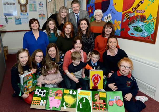 Members of Lurgan Deaf Club have created specially designed tactile books for local children who are visually impaired. Front row Blathnaid and Eibhleann Girvan, their mum Eleanor with Nessa. Ann Sterritt with her son Ben, Connal and Meadbh Bustard with Cara. Second row Alison Rooney Sensory Disability Team Manager, Adele Magill social worker, Jill McKeown Artist, Eilish Kilgallon Community Access Worker for Deaf people, Una McConville Social Worker, Back row Pat McAteer Specialist Services Manager, Southern Trust Beverley Lappin Social Worker, Kath Byrne Lurgan Deaf Club.