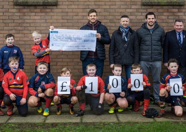 P6 player Sam Beckwith presents the cheque for £1,000 to Chris Henry (ex-Ulster and Ireland International player).