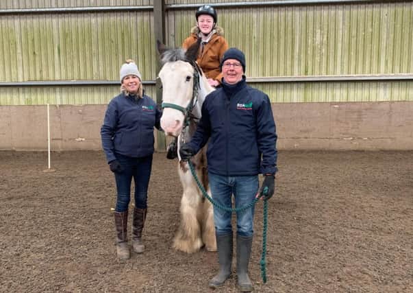 Instructor Judith Watt and volunteer Jonathan Stirling with a young rider.