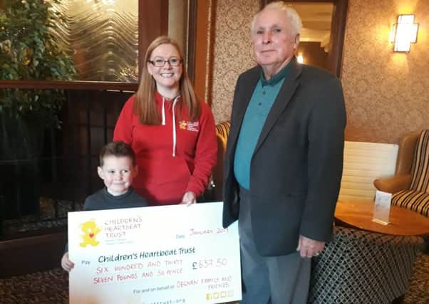 Joe Degnan and his grandfather Billy present Lynn from Childrens Heartbeat Trust with a cheque for £637.50.