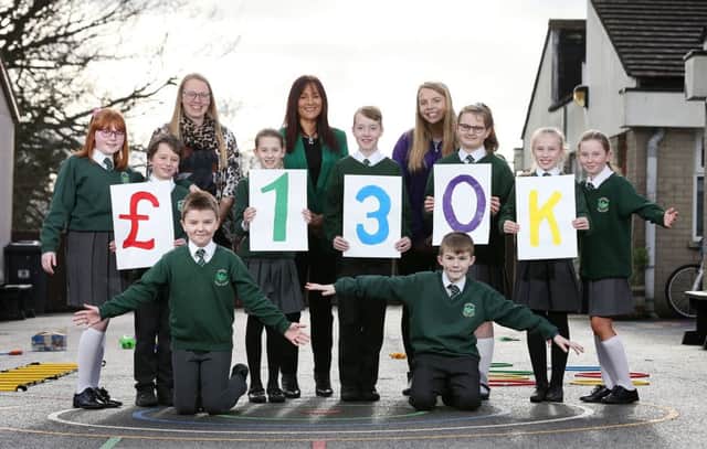 Vicky Logan and pupils from Oakfield Primary School with Aisling Press, head of Branch Banking, Danske Bank and Carla McCoubrey, project worker at Action Mental Health. Children across Northern Ireland are set to benefit from £130k raised for Action Mental Health by the banks employees and customers.