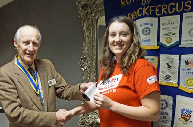 Carrickfergus Rotary Club president Colin de Fleury presents a donation for the work of Action Cancer to the charity's representative Amy Reynolds.