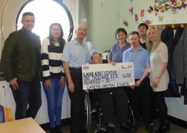 The Watson family have presented money raised from the Christmas lights display at their home to Larne Adult Centre.
