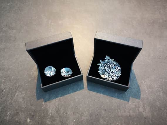 The cufflinks and brooch designed by Vera McCullough. The jewels include Alexandrite and Garnet, the birthstones of the Duke and Duchess of Cambridge.